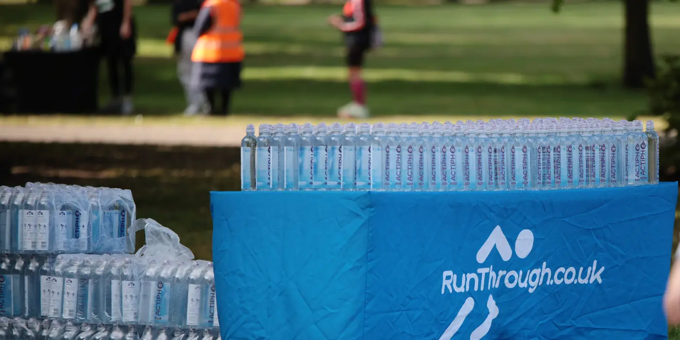 A RunThrough volunteer at a water station on the course